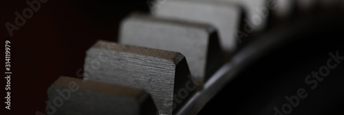 Billede på lærred Closeup of metal cogwheel on dark background as part of full machine and steampu