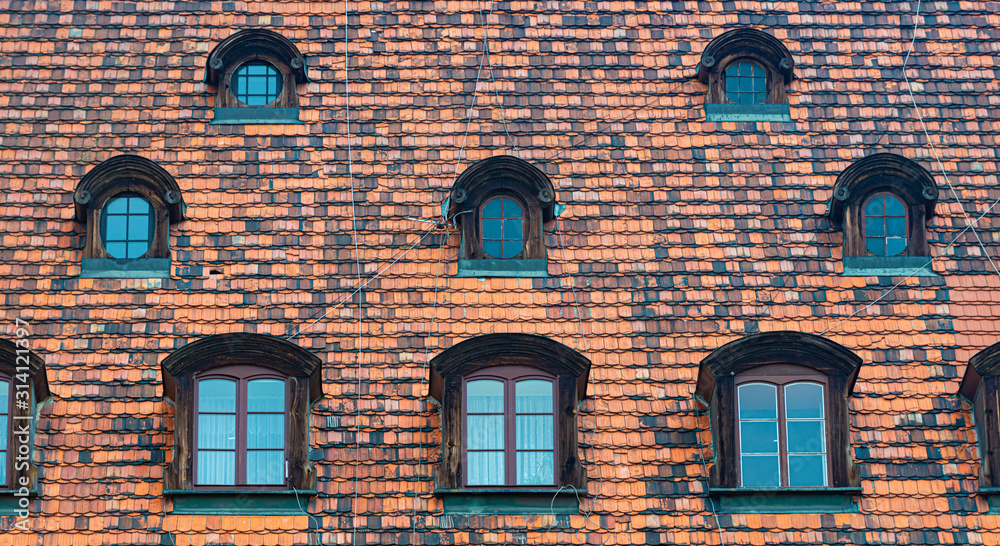 Obraz premium Tiled house roof with window in Wroclaw, Poland