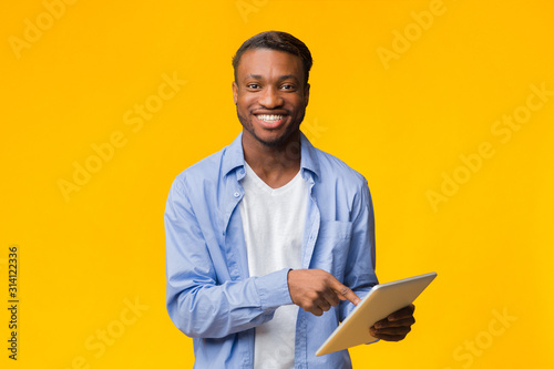Smiling African American Guy Using Digital Tablet, Studio Shot
