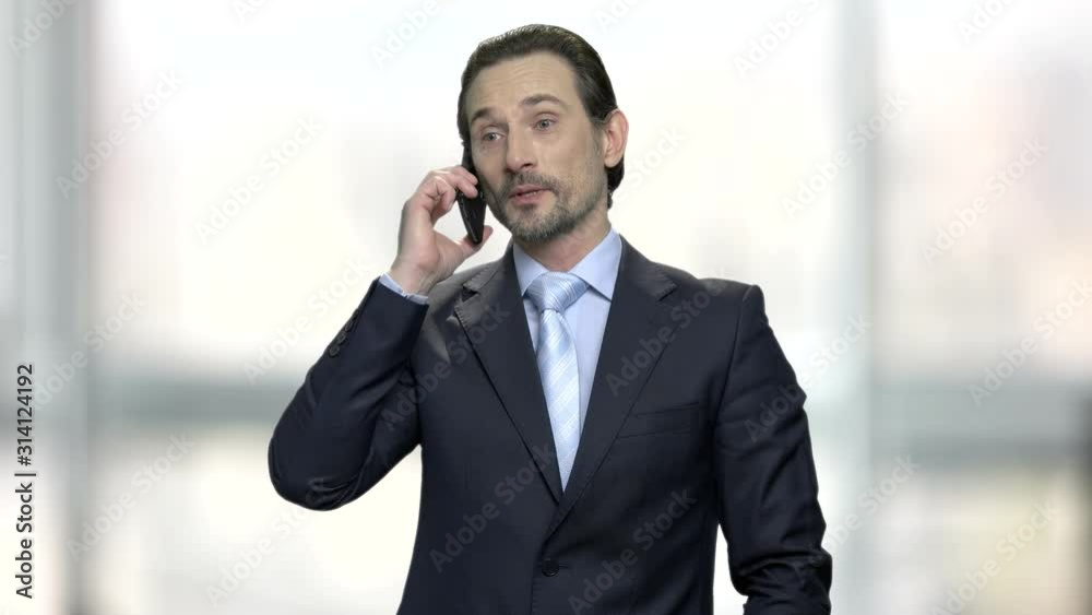 Handsome businessman talking on cell phone. Attractive man in business suit using mobile phone on blurred background. People, business, communication. Handsome businessman talking on cell phone. Attractive man in business suit using mobile phone on blurred background. People, business, communication.