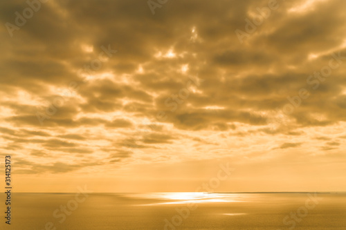 Yellow Sunset on the sea with overcast sky.  Orange pastel tone © pcruciatti