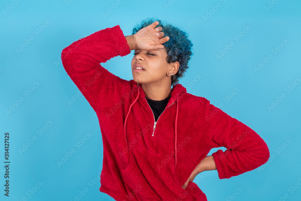 young afro american woman or girl isolated on blue background with expression of pain or symptoms