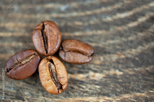 Background of roasted coffee beans, four grains in the form of a leaf
