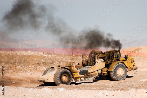 Heavy Construction Equipment Scraper emitting diesel fumes