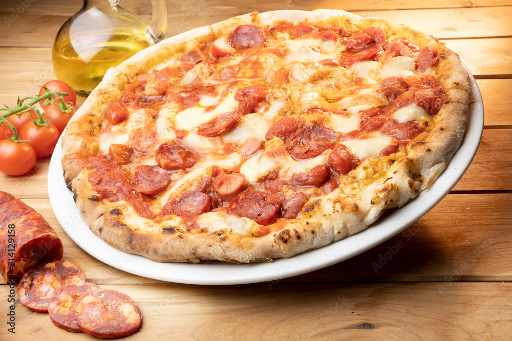 pizza with salami on the wooden table pizza with salami on the wooden table