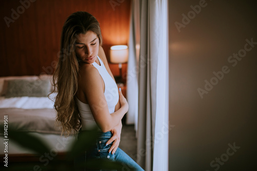 Beautiful young woman sitting by the window