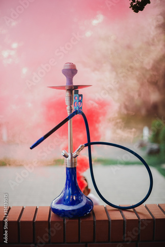 Hookah outdoors on a background of colored smoke