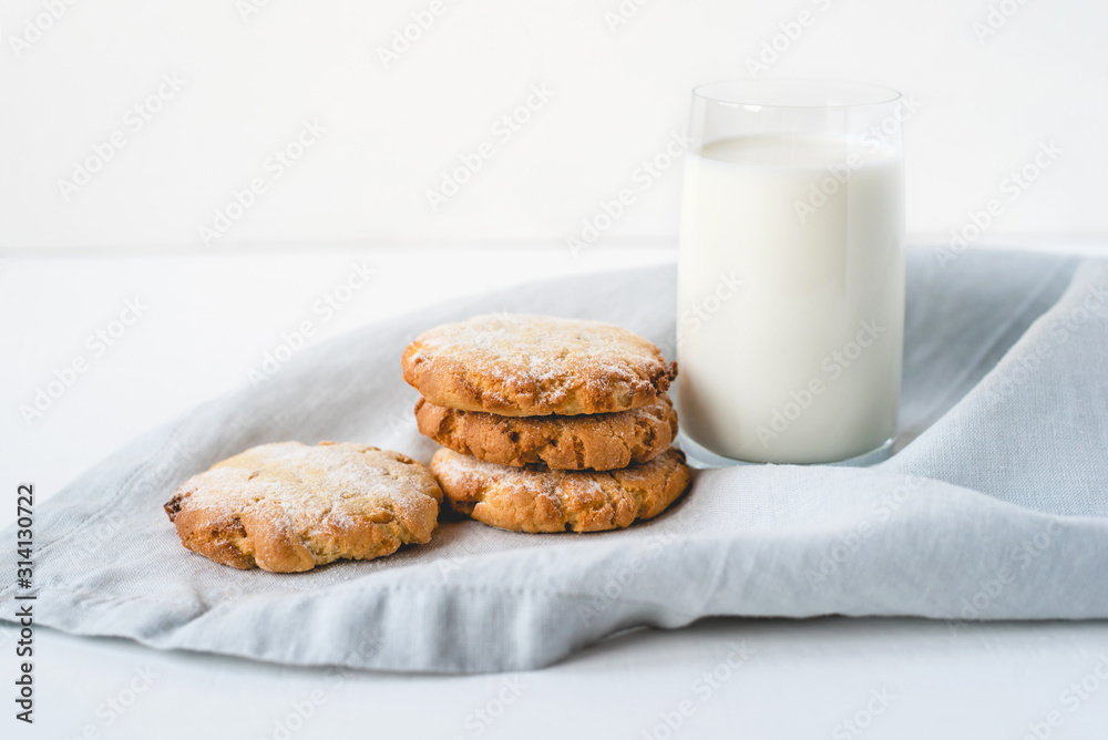 Stacked cookies on a linen napkin and a glass of milk. Close up. Stacked cookies on a linen napkin and a glass of milk. Close up.