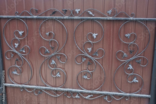metal texture of black bars with forged pattern on an iron brown wall fence