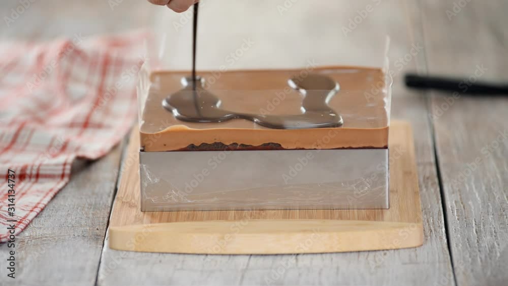 Glazing chocolate cake with melted chocolate. Woman pouring chocolate over cake. Homemade cocoa layered cake. Glazing chocolate cake with melted chocolate. Woman pouring chocolate over cake. Homemade cocoa layered cake.