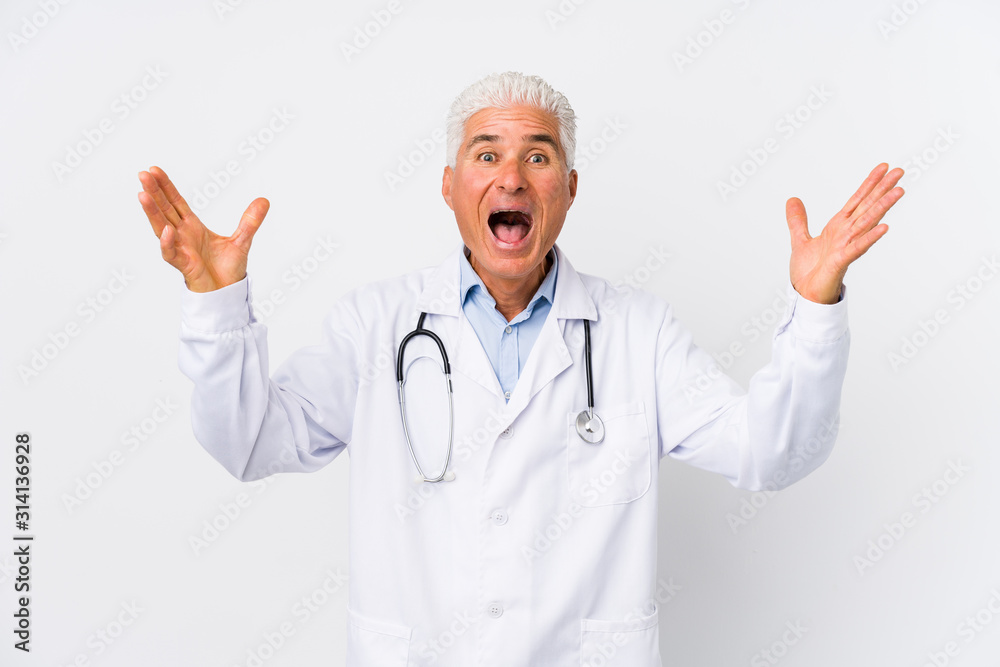 Mature caucasian doctor man receiving a pleasant surprise, excited and raising hands. Mature caucasian doctor man receiving a pleasant surprise, excited and raising hands.