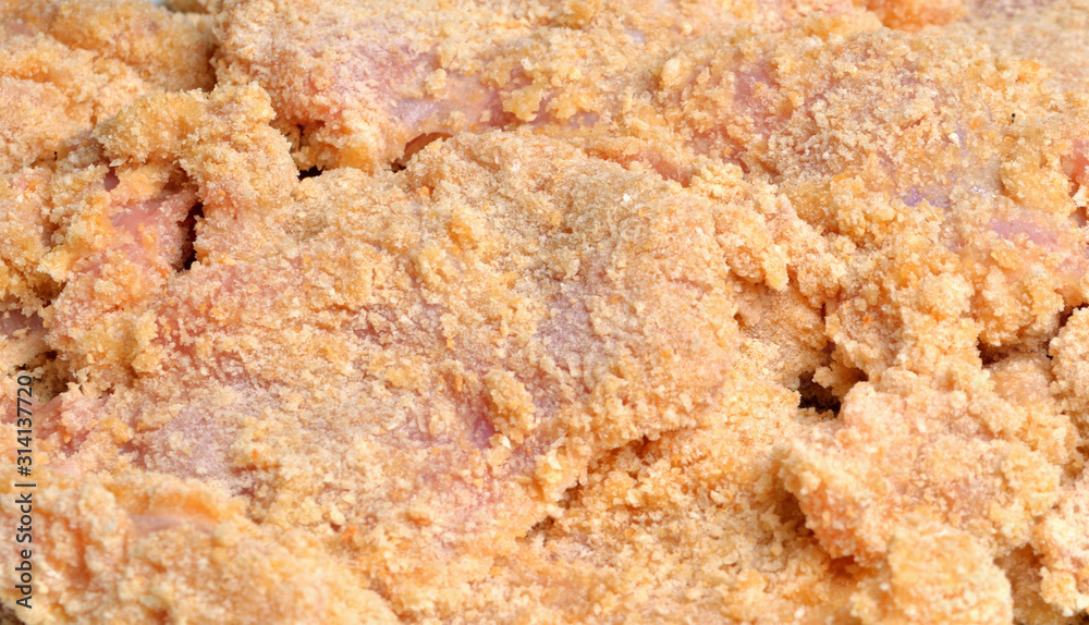Detail of bread crumbs on cutlet - typical Czech coated meat in breadcrumbs, flour and egg before frying in oil Detail of bread crumbs on cutlet - typical Czech coated meat in breadcrumbs, flour and egg before frying in oil