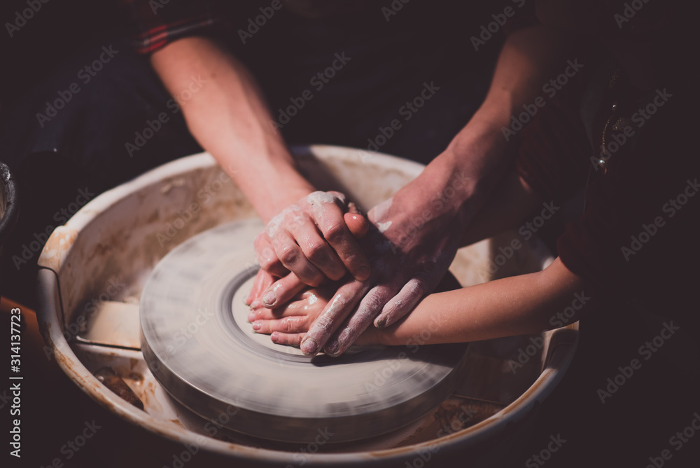 Potter with his daughter make her first clay pot Potter with his daughter make her first clay pot