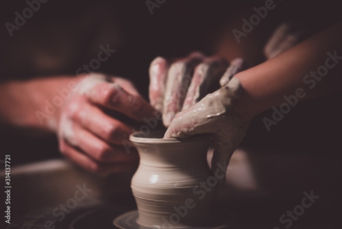 Potter with his daughter make her first clay pot