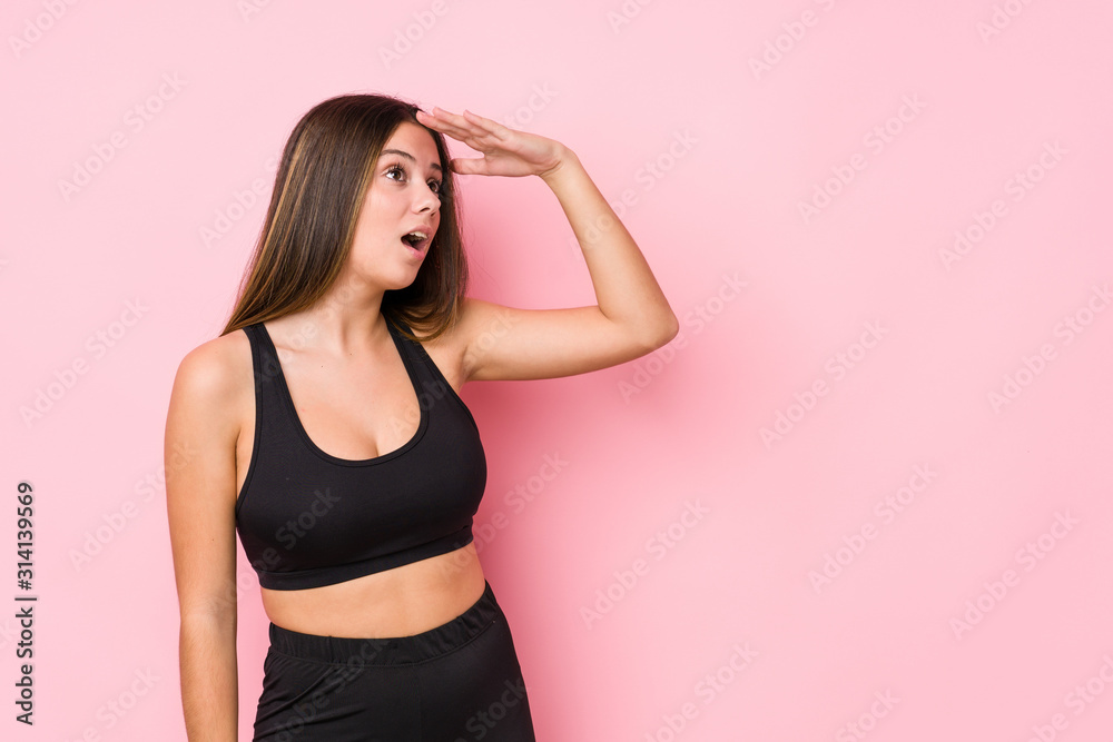 Young fitness caucasian woman isolated looking far away keeping hand on forehead. Young fitness caucasian woman isolated looking far away keeping hand on forehead.