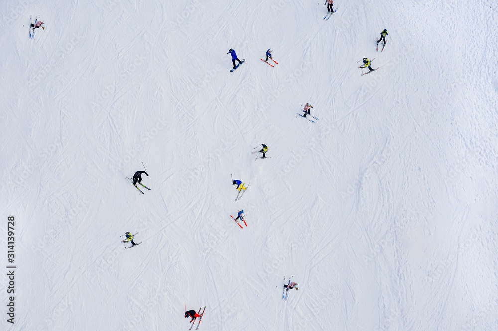 Aerial drone view on skiers on ski slope at winter. - obrazy, fototapety, plakaty 