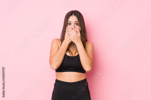 Young fitness caucasian woman isolated shocked covering mouth with hands. © Asier