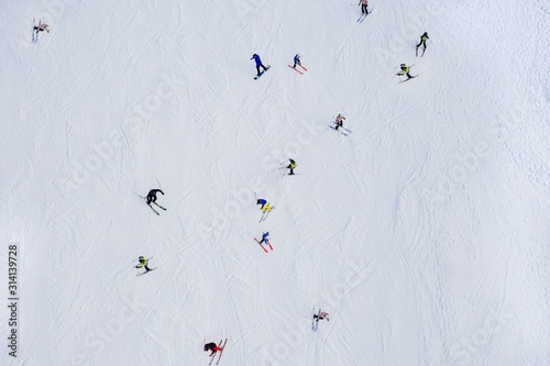 Aerial drone view on skiers on ski slope at winter. photo