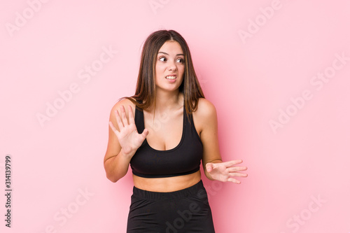 Young fitness caucasian woman isolated rejecting someone showing a gesture of disgust.