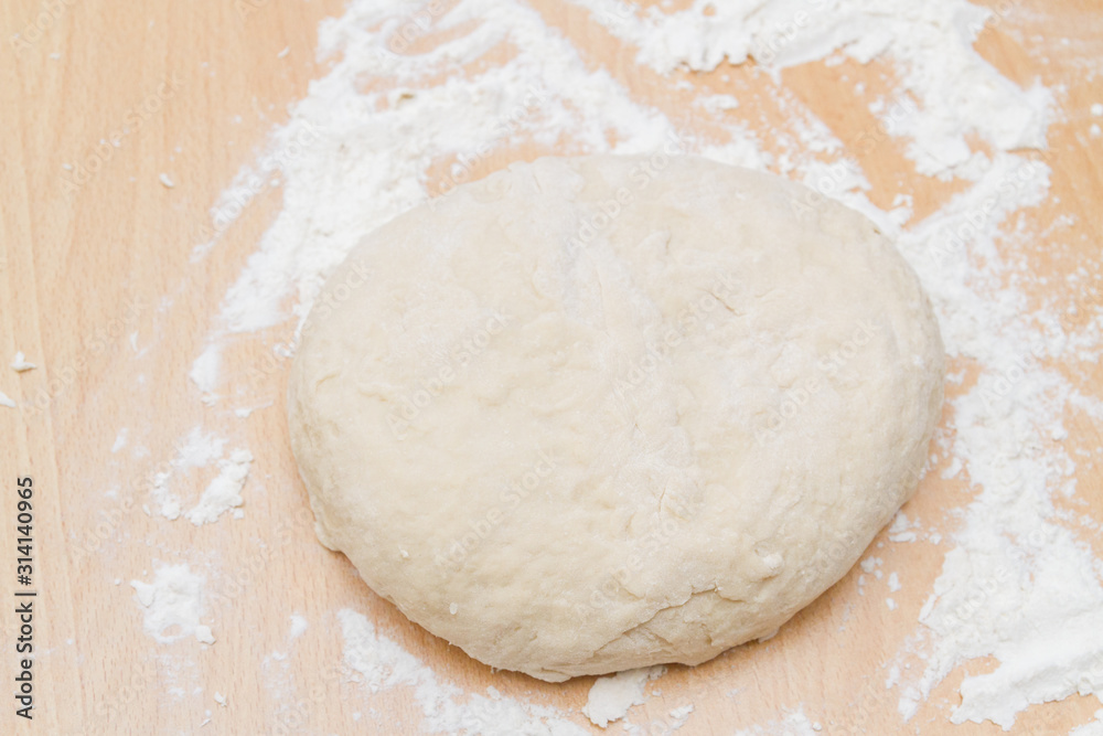 Prepared kneaded dough on a wooden table at home Prepared kneaded dough on a wooden table at home