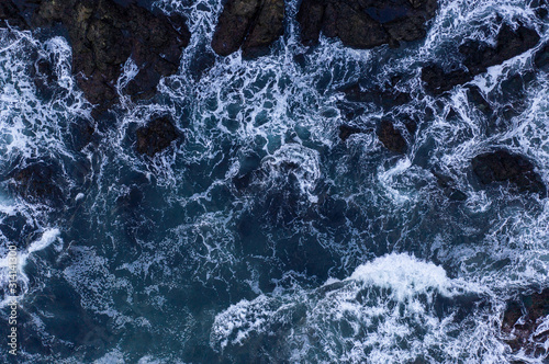 Top down view of giant ocean waves crashing and foaming