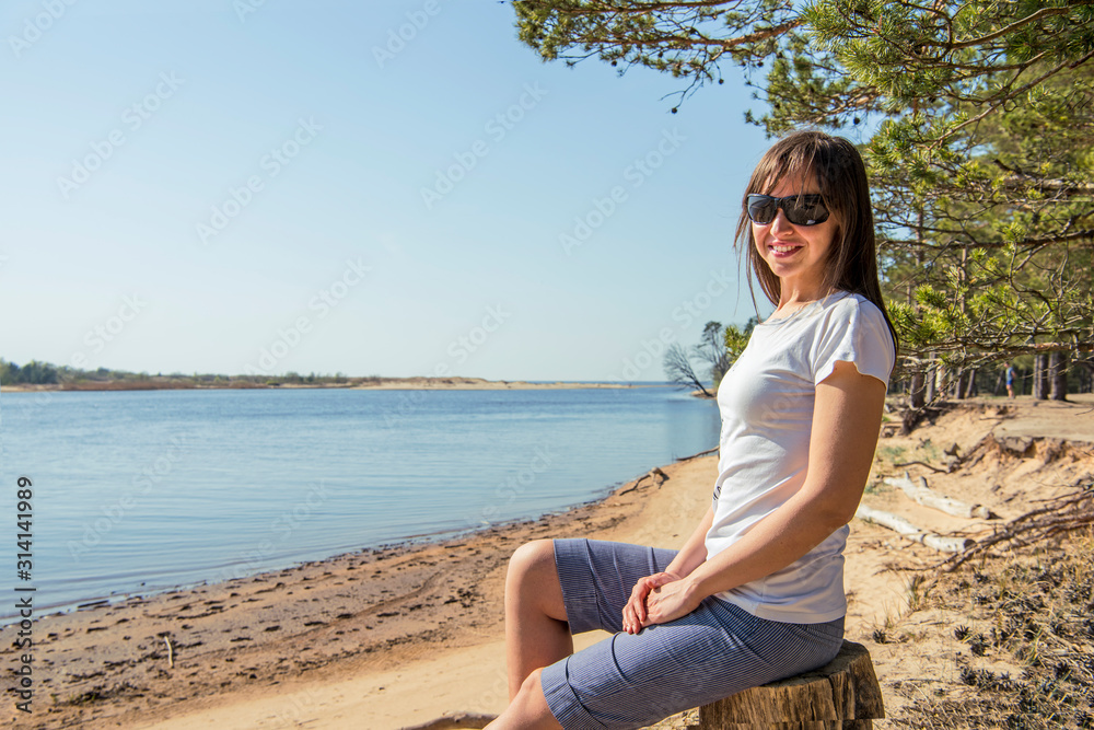 Portrait of smiling young woman laying on sea coast