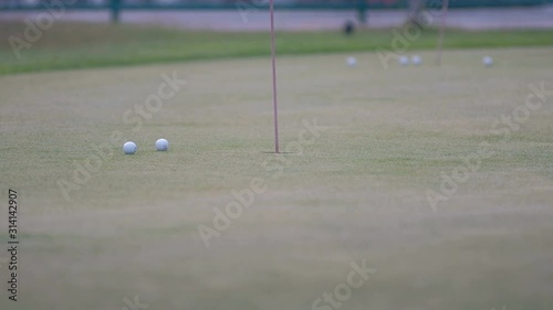 golfer putting golf ball in to the hole