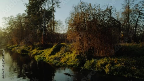 Scenic video of Polish river Wkra at sunset with gentle mist rising above water, almost fantasy scenery. Drone, aerial shot. Cinematic grading. photo