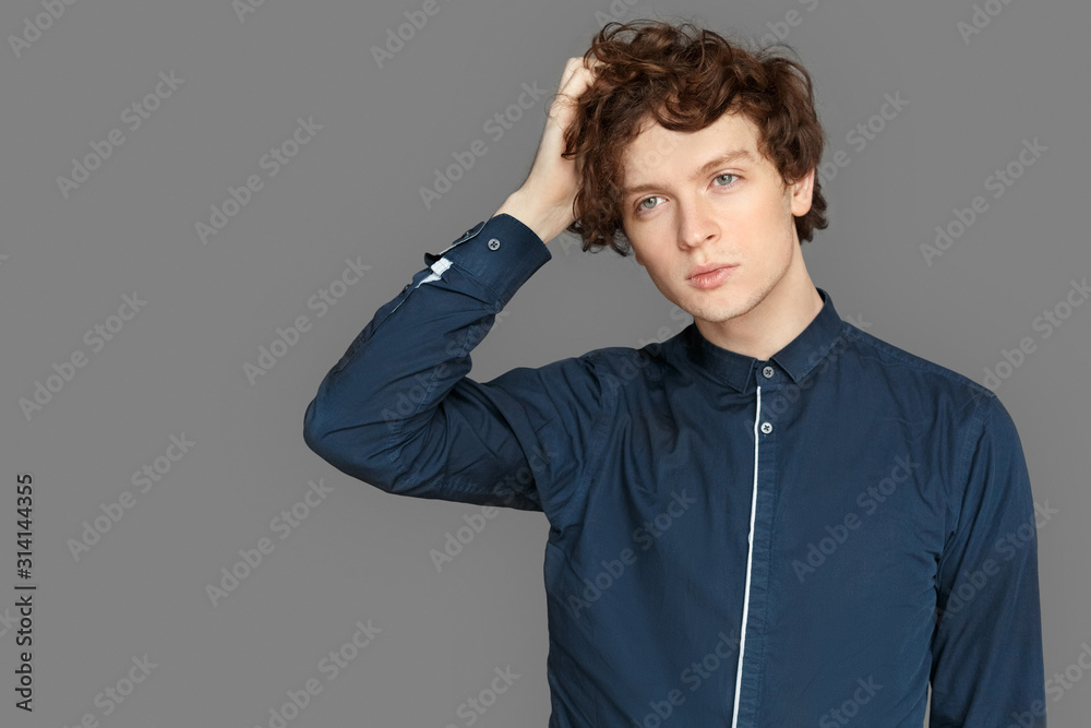Freestyle. Teenager boy standing isolated on grey holding head thoughtful Freestyle. Teenager boy standing isolated on grey holding head thoughtful