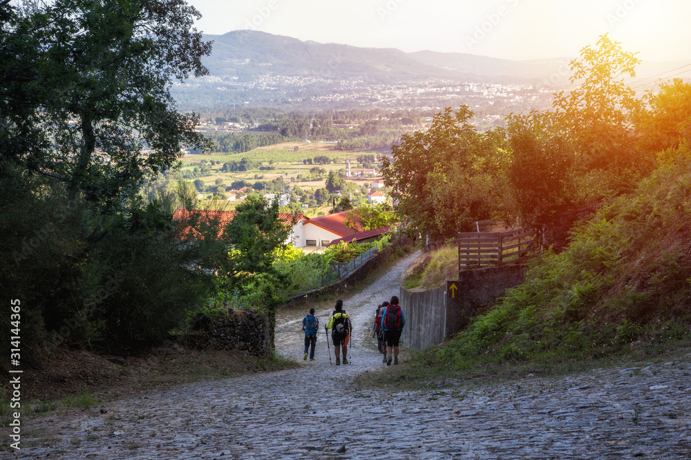 Ταπετσαρία A group of pilgrims walking the camino de santiago at sunset
