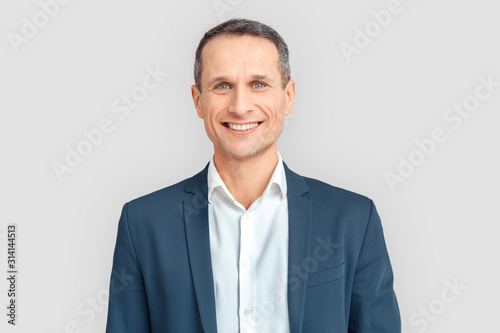 Freestyle. Mature businessman standing isolated on white smiling cheerful close-up photo