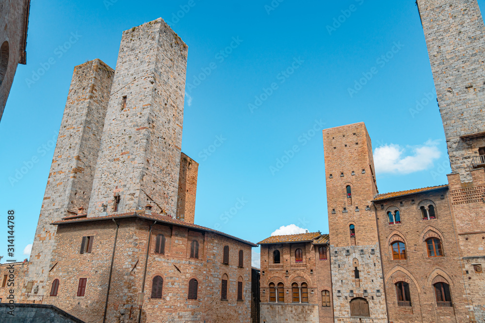 Panoramic view of famous Piazza del Duomo in the historic town of San Gimignano on a sunny day, Tuscany, Italy