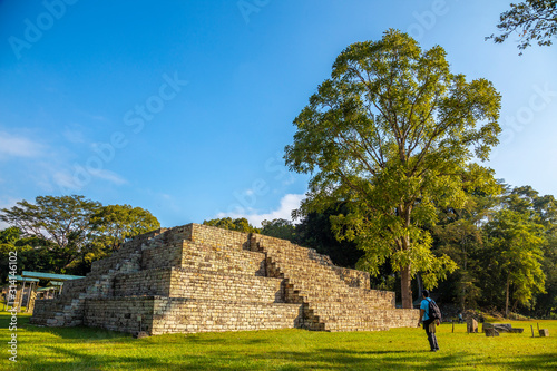 A young man watching A Mayan pyramid at The Copan Ruins temples. Honduras