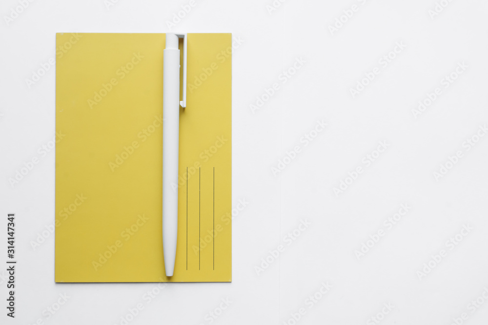 yellow postcard and a pen on white background, write a list yellow postcard and a pen on white background, write a list