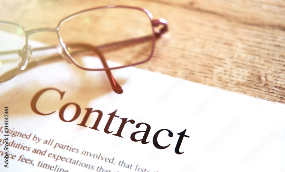 Contract sheet with glasses on a wooden background Contract sheet with glasses on a wooden background