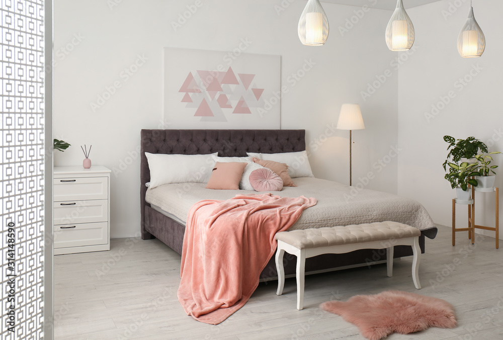 Stylish room interior with large comfortable bed - obrazy, fototapety, plakaty 