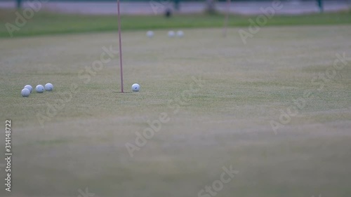 golfer putting golf ball in to the hole