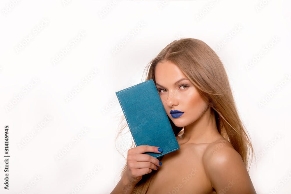 Portrait of young blonde woman with long hair, blue lips and nails, which holds a leather turquoise wallet. Fashion model . Bare female shoulders. The best gift for glamour women. Copy space Portrait of young blonde woman with long hair, blue lips and nails, which holds a leather turquoise wallet. Fashion model . Bare female shoulders. The best gift for glamour women. Copy space