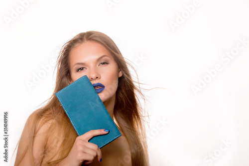 Portrait of young blonde woman with long hair  blue lips and nails  which holds a leather turquoise wallet. Fashion model . Bare female shoulders. The best gift for glamour women. Copy space
