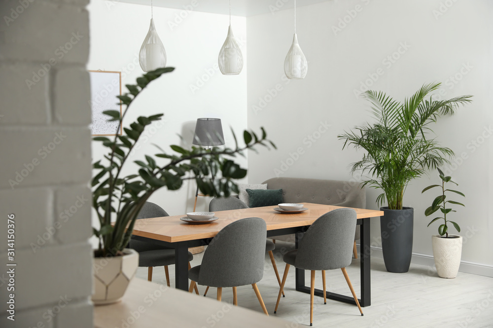 Stylish wooden table in modern room interior Stylish wooden table in modern room interior