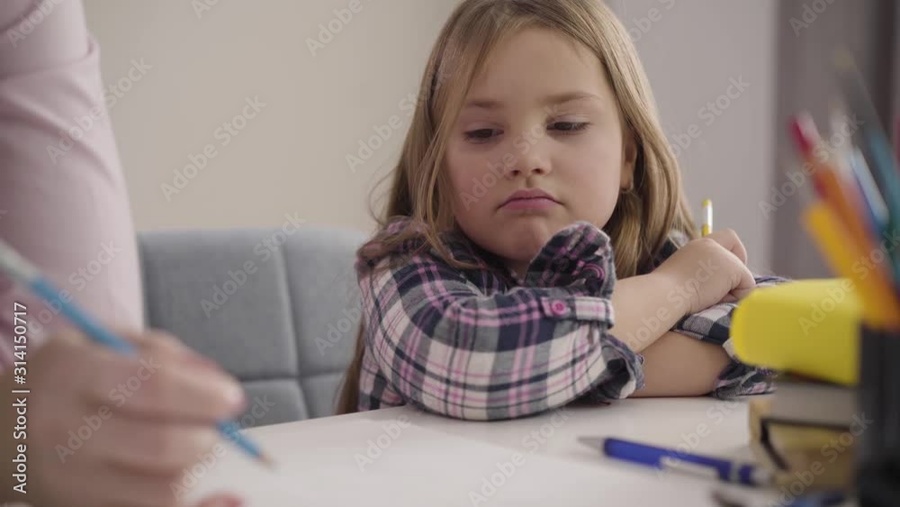 Portrait of cheerful Caucasian child playing tic-tac-toe with unrecognizable mother. Happy girl making victory gesture and smiling. Taking break, education, intelligence. Portrait of cheerful Caucasian child playing tic-tac-toe with unrecognizable mother. Happy girl making victory gesture and smiling. Taking break, education, intelligence.