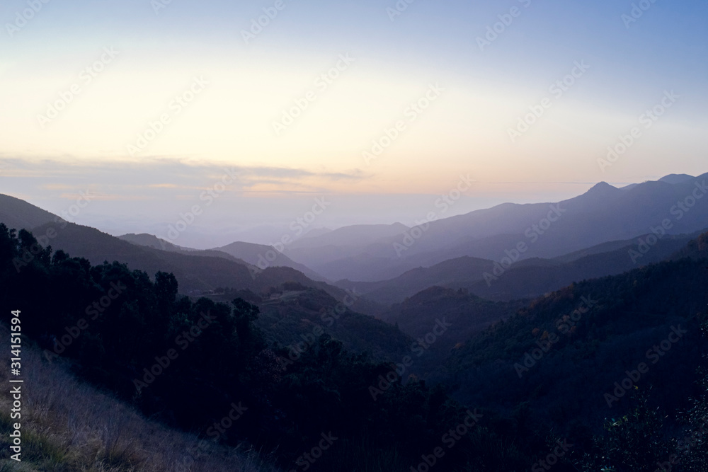 Foggy sunset over mountain landscape silhouette