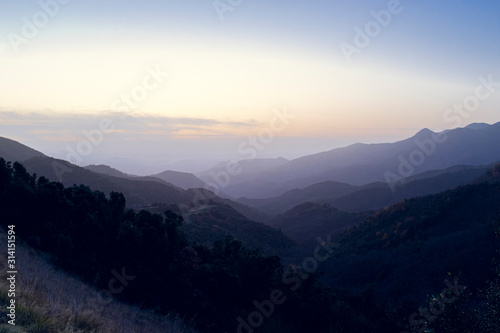 Foggy sunset over mountain landscape silhouette