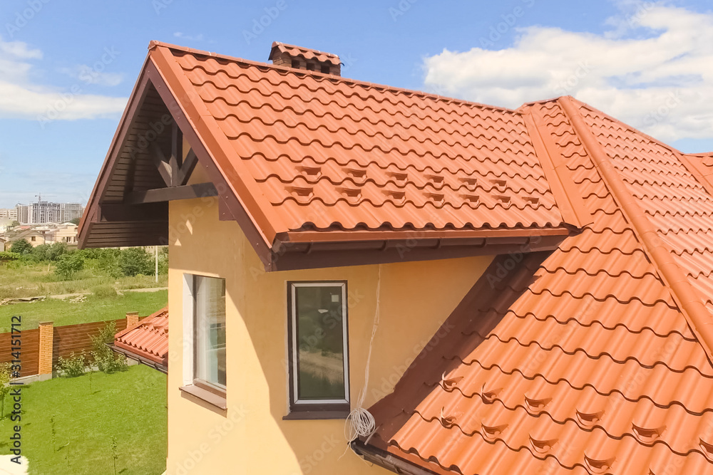 House with a new roof made of orange metal. View from above. Cor House with a new roof made of orange metal. View from above. Cor