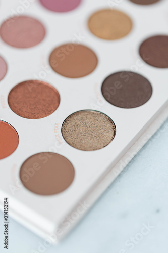 Neutral eyeshadow makeup palette on marble background
