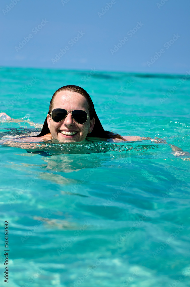 Hübsche Frau schwimmt im türkis blauen Meer in der Karibik bei Varadero in Kuba, Cuba