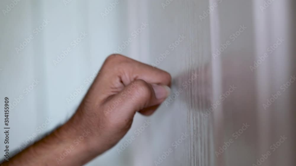 Side view hand knocking on wooden door