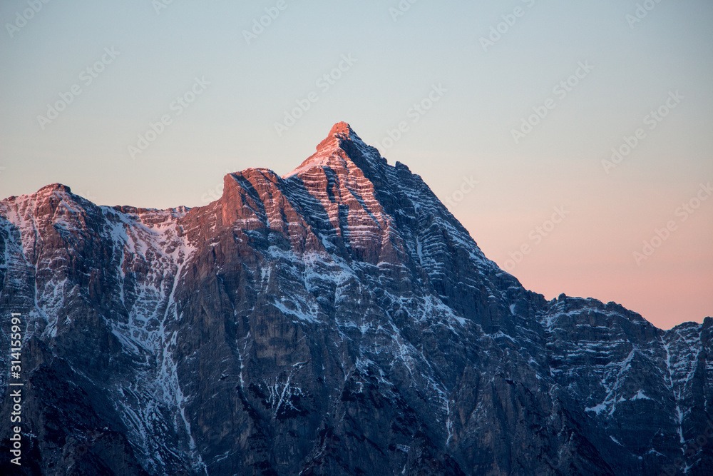 Obraz premium Mountain portrait Birnhorn Saalbach sunset purple light clouds snowy mountain