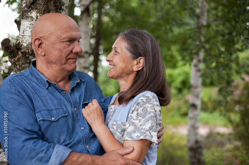older man and woman in birch grove © DariaTrofimova