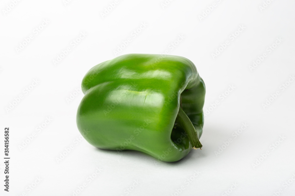 One whole green and fresh sweet bell pepper Isolated on a white background. Non-gmo healthy vegetarian eating concept One whole green and fresh sweet bell pepper Isolated on a white background. Non-gmo healthy vegetarian eating concept